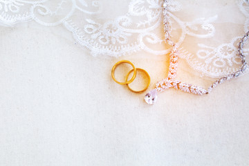 Obraz na płótnie Canvas Beautiful top view flat lay a pair of gold rings necklace and beautiful flower bouquet on white background, wedding celebration or valentines concept