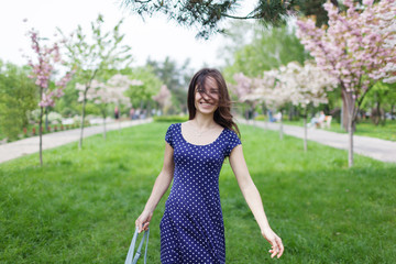 Young happy woman smiling enjoying spring day.Sakura tree blooming.Soft and tender. Gorgeous flower and female beauty. Woman in spring flower bloom