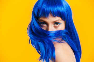 Portrait closeup of seductive nice woman wearing blue wig looking and poising at camera