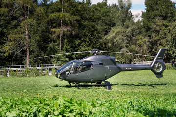 Grauer Hubschrauber auf einer Wiese stehend © ansi29