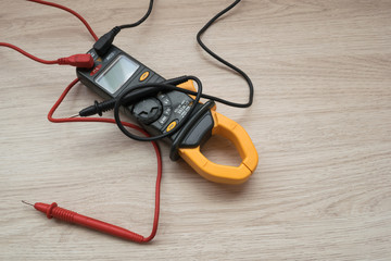 Clamp meter digital on wooden background.