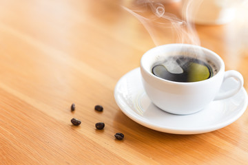 Hot coffee with smoke on the table in coffee shop
