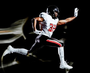 one african american football player man studio shot isolated on black background with light...