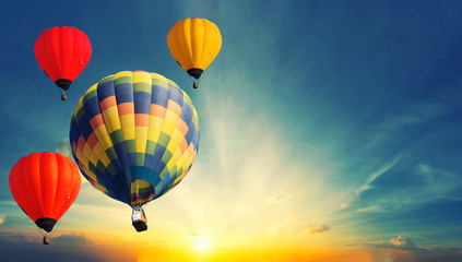 Colorful balloons floating in the sky at sunset.