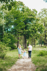 Rear view of young family walking in forest
