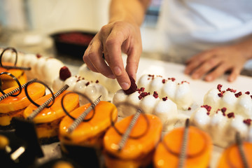 Young woman decorating raspberry cookies,stock photo