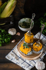 Baked corn with spiced butter on a rustic wooden background. Barbecue food. Thanksgiving Day. Autumn harvest.