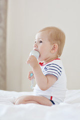 Baby boy Brushing Teeth on bed, light background, close-up, portrait.The concept of a healthy lifestyle