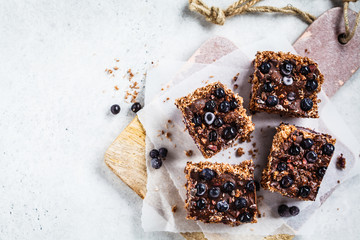 Raw vegan coconut chocolate dessert with blueberries, top view . Healthy vegan food concept.