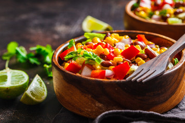 Traditional corn bean mexican salad in a wooden bowl. Mexican food concept.