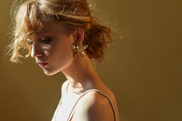 Earrings and jewelry in ear of a sexy blonde woman pressed. Perfect blonde girl, gorgeous...
