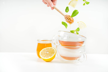 Autumn tea with mint and lemon with ingredients - fresh mint leaves, sliced lemon and honey, white background copy space
