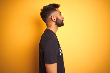Arab indian hispanic safeguard man wearing security uniform over isolated yellow background looking...