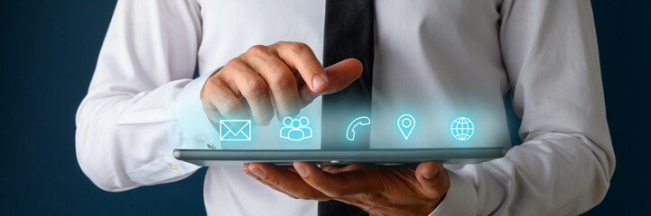 Front view of businessman using digital tablet with icons of contact