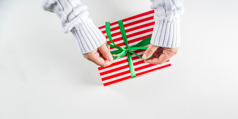 Female hands hold xmas gift boxes, champagne and glasses , white background with copy space. Christmas and New Year concept banner