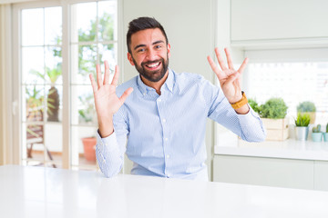 Handsome hispanic business man showing and pointing up with fingers number nine while smiling confident and happy.
