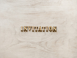 Letters of the alphabet in the form of the word INVITATION on a white board. Top view