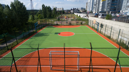 Fototapeta premium Soccer field among tall houses.
