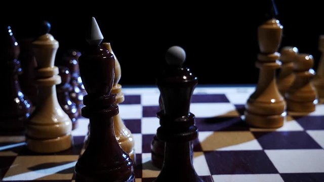 Chess piece of a king swinging on a chess board in slow motion