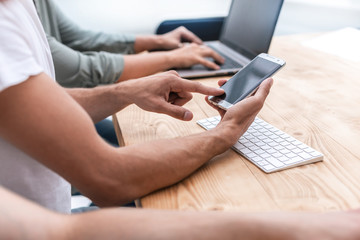 close up. a young man uses his smartphone in the workplace.