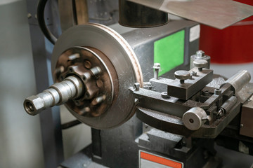 Mechanic man repairing brake use lathe tool polishing disc brakes of cars working automatic. - rebuild disc brake surface.