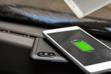 Phone battery wireless charge sharing technology. Wireless charge sharing smartphone in the car in rainy weather
