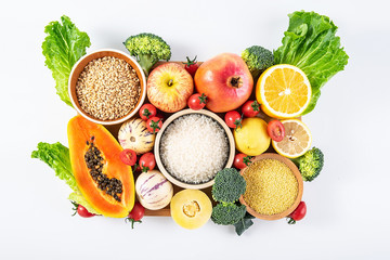 A pot of fresh seasonal fruits and vegetables and grain on a white background