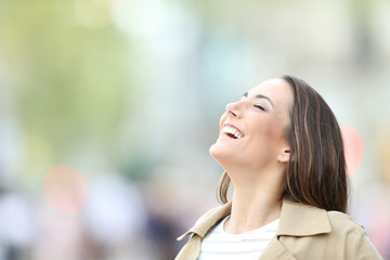 Happy woman breathing fresh air in the street