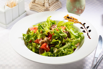 Warm salad with tomato and meat