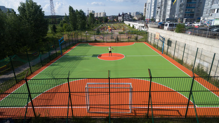Soccer field among tall houses.