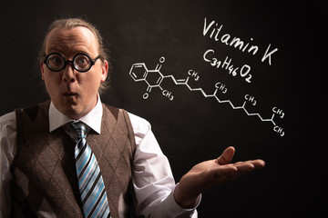 Professor presenting handdrawn chemical formula of Vitamin K