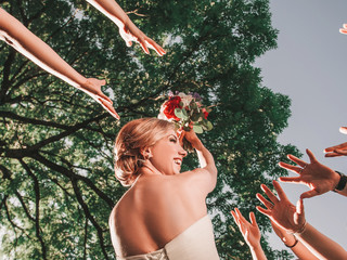 cheerful bride throws a wedding bouquet to her friends.