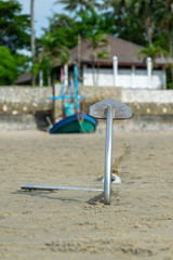 Fototapeta na wymiar Stainless boat anchor on the beach