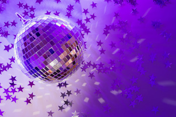 Christmas disco ball with rays on neon blue. Creative Xmas party background with copy space.