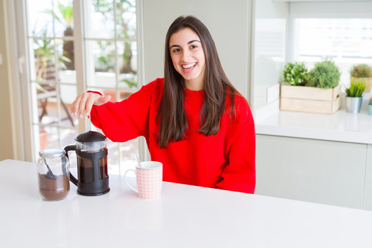 Young beautiful woman making morning coffee smiling, preparing a cup of latte for breakfast