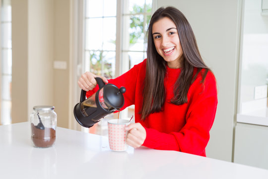 Young beautiful woman making morning coffee smiling, preparing a cup of latte for breakfast