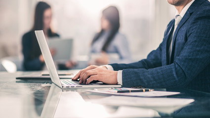 successful businessman working on laptop with financial data at the workplace in a modern office.