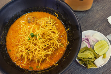 Khao Soi noodles tasty dish on the wooden table from the north of Thailand