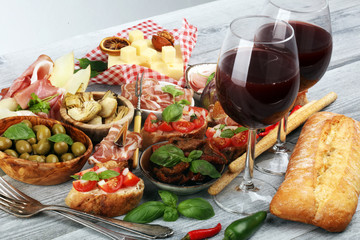 Italian antipasti wine snacks set. Cheese variety, Mediterranean olives, Prosciutto di Parma, tomatoes, artichokes