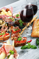 Italian antipasti wine snacks set. Cheese variety, Mediterranean olives, Prosciutto di Parma, tomatoes, artichokes