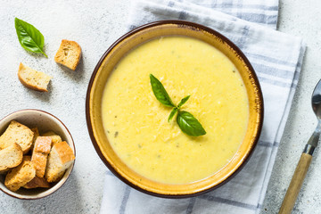 Zucchini Cream soup with basil and croutons on white.