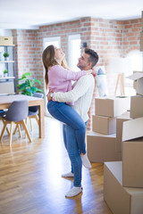 Fototapeta na wymiar Young beautiful couple hugging in love celebrating very happy moving to new apartment