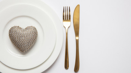 Table setting, wedding reception. Gold cutlery on white set of dishes, white background