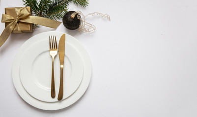 Table setting, xmas, new year. Gold cutlery on white set of dishes, white background
