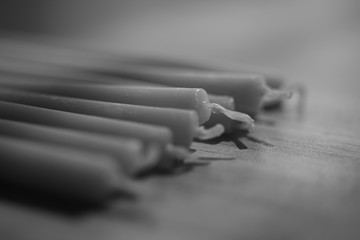 row of new long candles on the table closeup, bw photo
