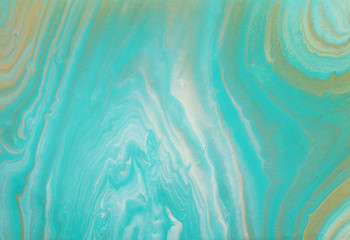 photography of abstract marbleized effect background. turquoise, gold, blue and white creative colors. Beautiful paint.