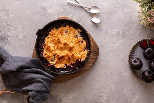 Plum Crumble In Cast Iron On Grey Background. Top View