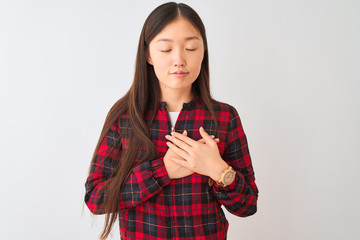 Young chinese woman wearing casual jacket standing over isolated white background smiling with hands on chest with closed eyes and grateful gesture on face. Health concept.