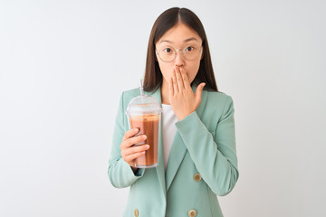 Young chinese woman drinking tomato smoothie over isolated white background cover mouth with hand shocked with shame for mistake, expression of fear, scared in silence, secret concept