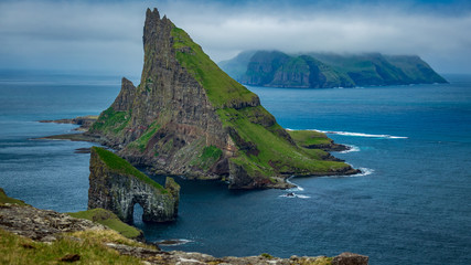 Amazing top view of Drangarnir gate in front of Tindholmur, Faroe Islands